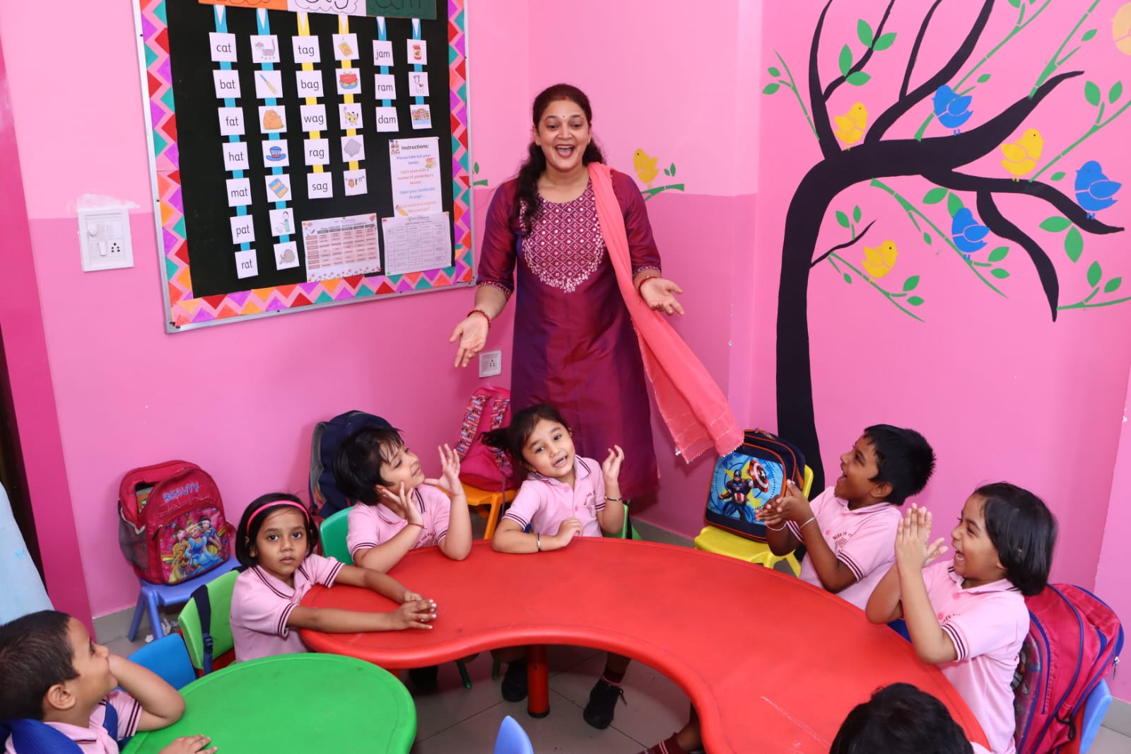 Educator guiding children through a hands-on activity at Neev